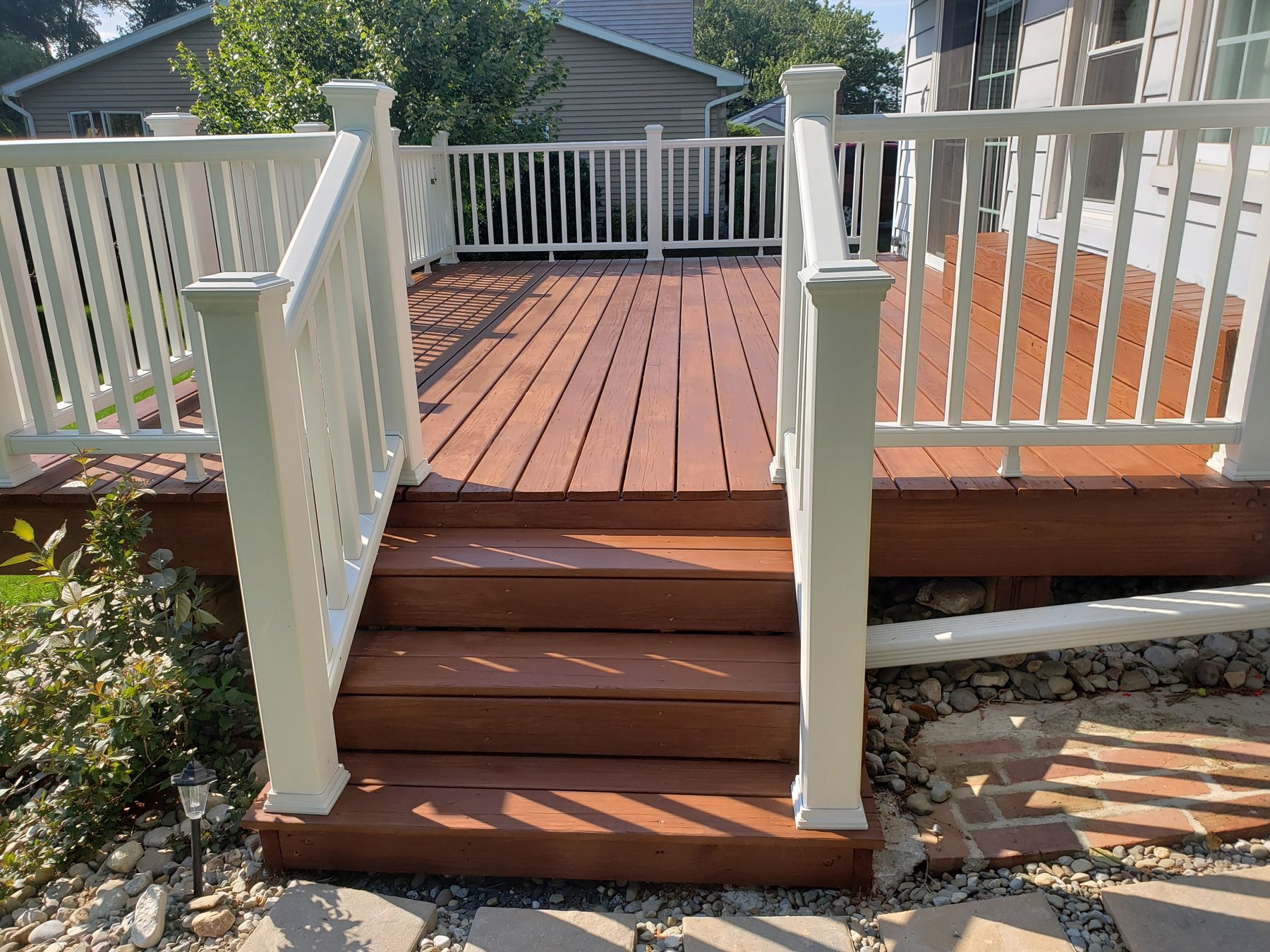 Freshly stained deck with white railings
