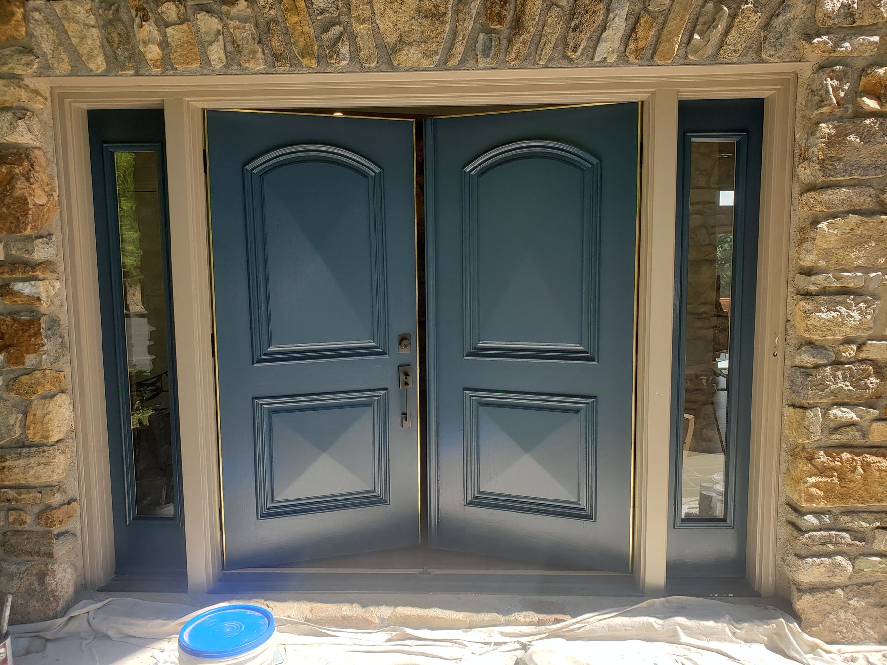 Home 8 Double front doors painted deep blue in a stone entry